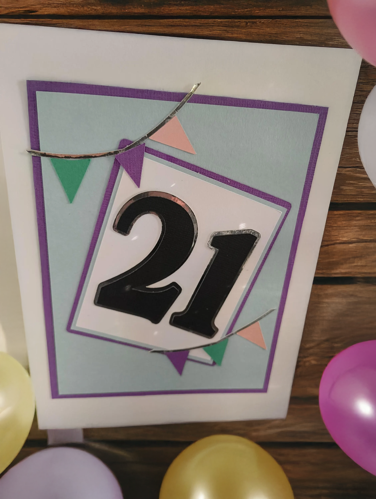 21st birthday card with colorful geometric design surrounded by balloons.